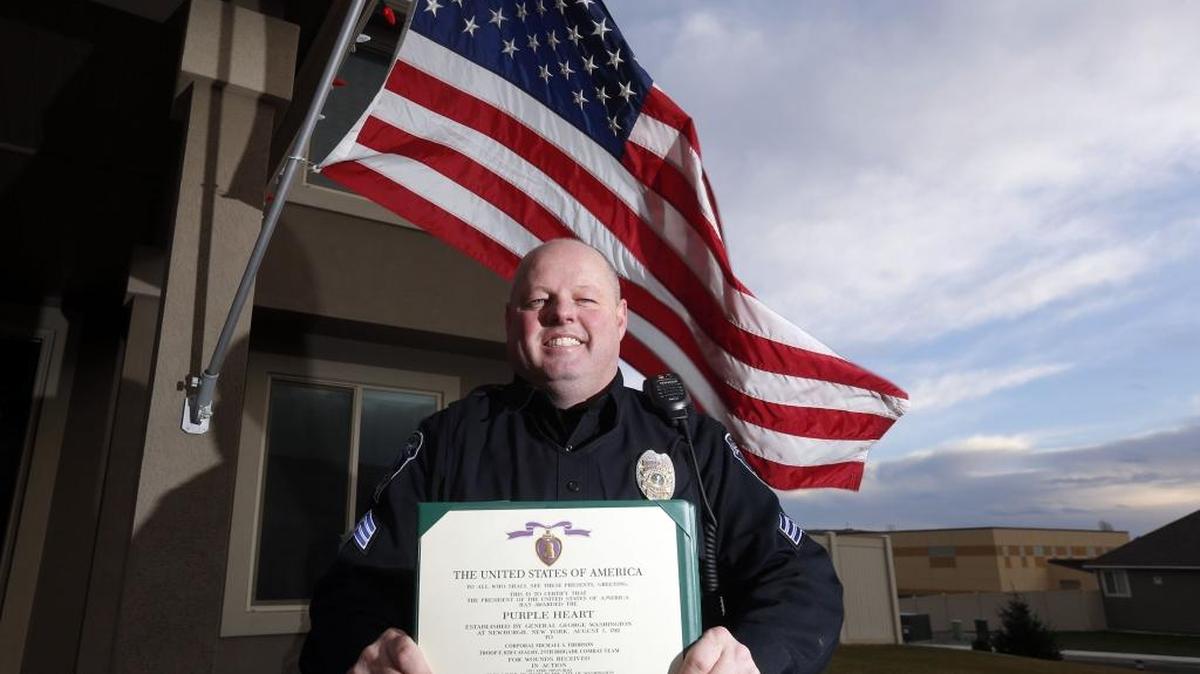 Connell Police Sgt. Shane Thorson poses for a photo at his home in Richland with the certificate for the Purple Heart he received in November. The award was a surprise for Thorson, who was injured in 2005 during a mortar attack at a military base in Iraq.