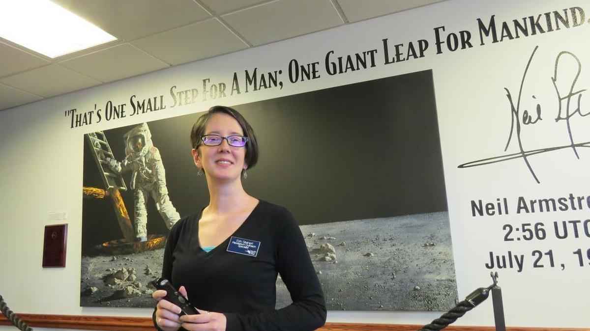 Erin Steinert holds the SCItouch planetarium controller in December 2016. It resembles a TV remote and allows the planetarium to be a more interactive experience.