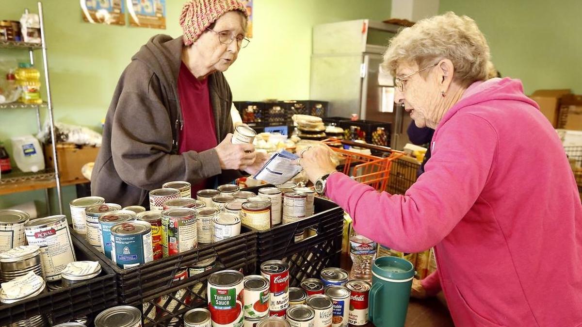 Tri-Cities Food Bank client Bonnie Rothwell, left, is helped by volunteer Helen Konkright at the Kennewick branch in December.