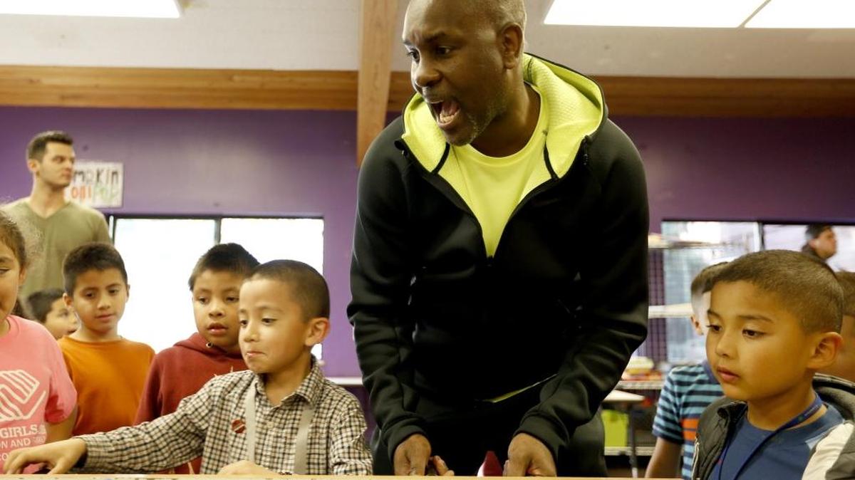 Former Seattle SuperSonics player Gary Payton reacts as Ramiro Rodriguez, 7, makes a shot playing foosball at the Boys & Girls Club in Pasco. Payton taught a basketball clinic Thursday and spoke at the club’s annual fundraising dinner. See story Page A2.