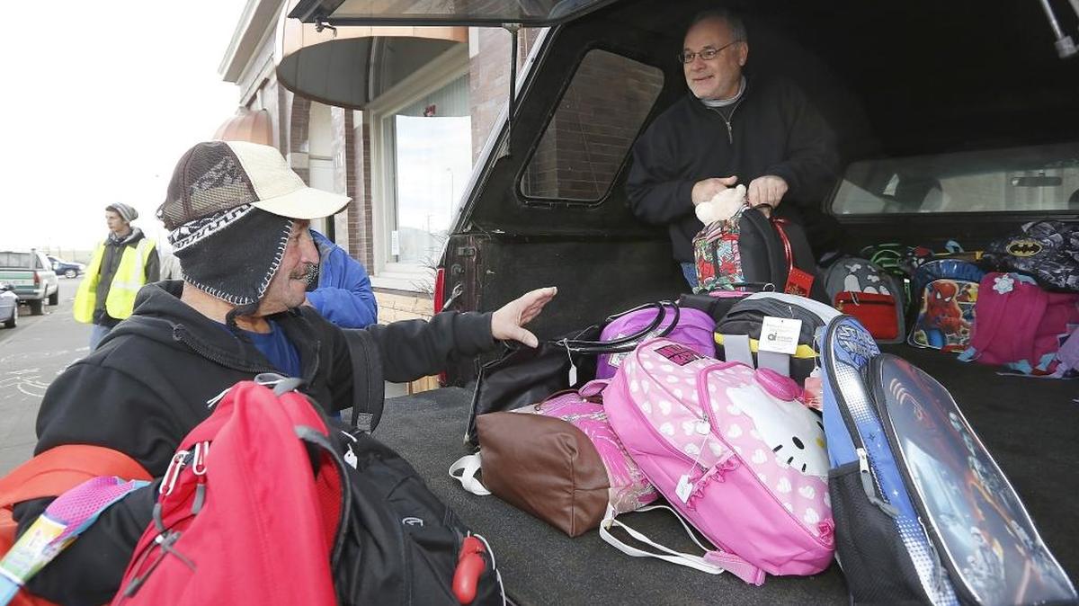 Mission client Juan Pulido, left, helps Kadlec employee Steve Baker unload 76 donated backpacks, filled with basic toiletries, snacks and toys, Tuesday at the Tri-City Union Gospel Mission in Pasco. Employees in the emergency room and X-ray departments at Kadlec Regional Medical Center collected the gifts for kids at the Women & Children’s Shelter, where there are currently 11 children staying with their mothers.