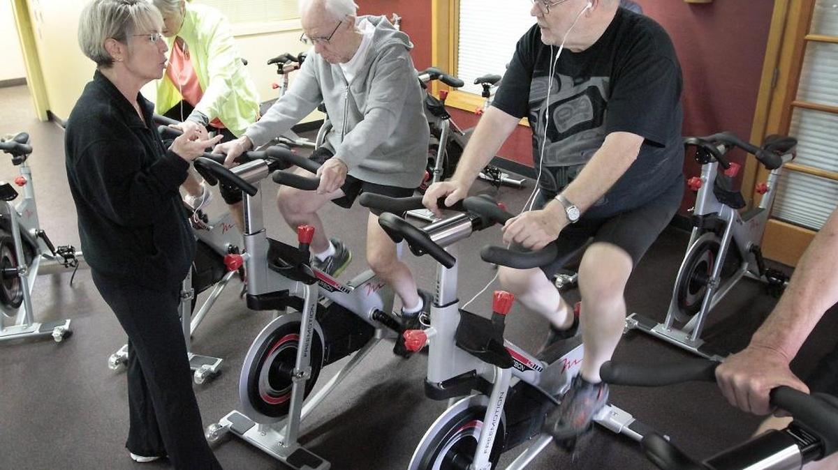 
Lori Powell, a Tri-City Court Club employee who is a certified personal trainer, talks with Debbie Crowley, from left, Clark Denise and John Goulet while they participate in a recent Pedaling For Parkinson’s class at the Kennewick club. The 10-week fitness class is being offered for free to people with the disease.
