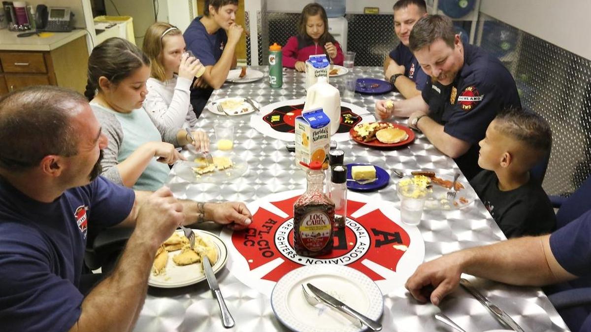 Richland Fire Chief Tom Huntington, right, and Jefferson Elementary second-grader Talon Lopez share a a conversation over breakfast Friday morning at Richland Fire Station 71, at the intersection of George Washington Way and Swift Boulevard. Lopez and three of his schoolmates were treated to a breakfast of pancakes, scrambled eggs, sausage and bacon cooked by the Richland firefighters after they “bought” the prize at an auction with points they earned in a school reading awards program. Lt. Joe DeRousie, fifth-grader Casey White, fifth-grader Annaliese Ekstrom, firefighter Jen Dawson, second-grader Jimena DeleMora and Capt. Zach Gould, from left, also join the meal. Watch a video at tricityherald.com/video