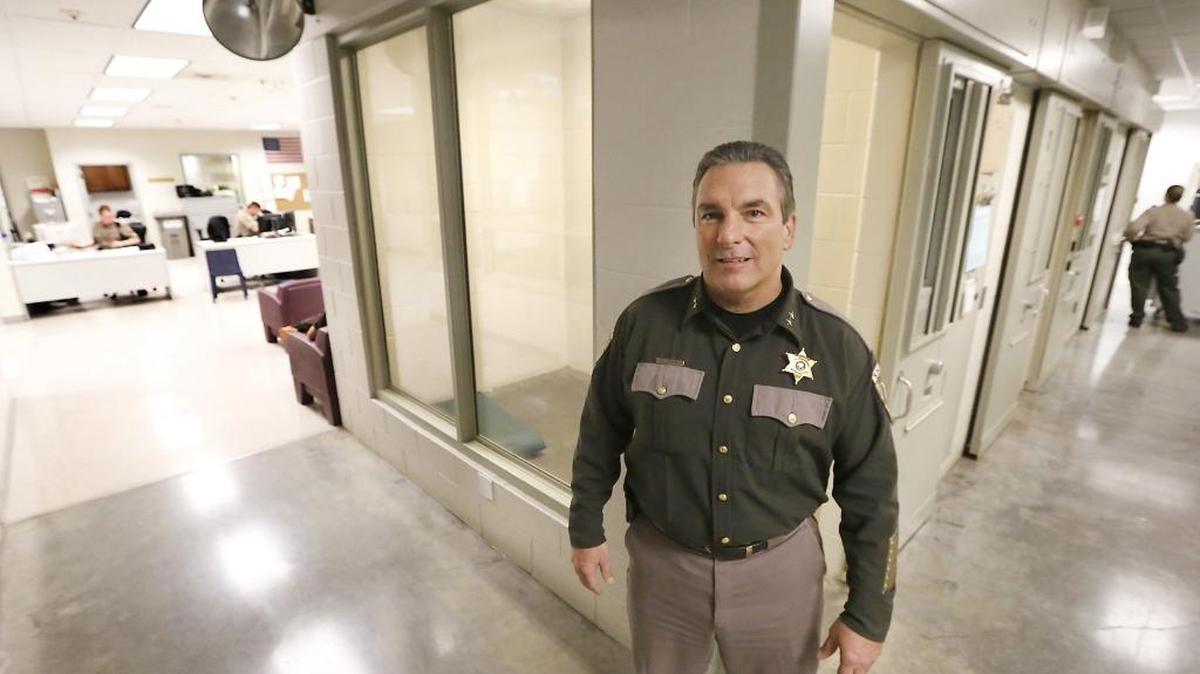 Interim Benton County Sheriff Jerry Hatcher stands in the jail near a cell modified with two near full-length windows used to hold inmates with mental health issues. The cell’s windows face the control room in the jail’s booking area, where corrections officers are able to continually monitor an inmate placed there.