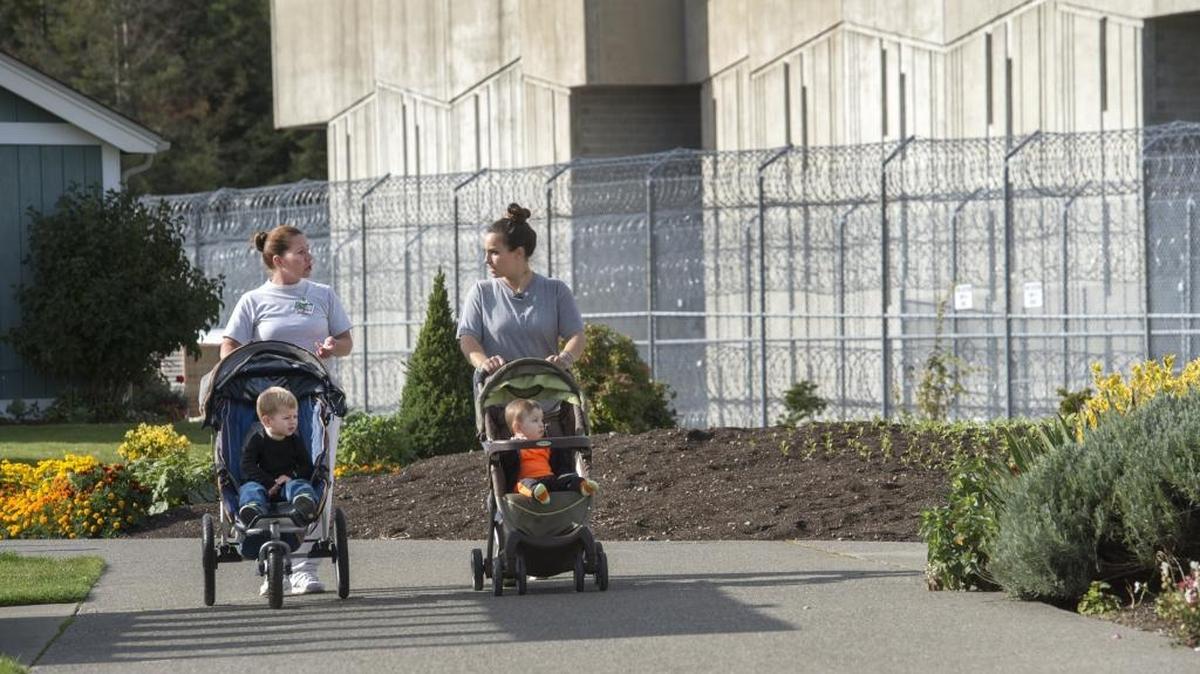 Despite the grim presence of fences topped with razor wire, Candida Suarez of Kennewick, right, and her son, Ezra, enjoy a sunny day walking with fellow inmate Ellen Oliver and her son, Aden. Both women are in the Residential Parenting Program at the Washington Corrections Center for Women in Gig Harbor.