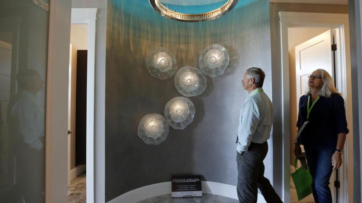 
Craig and Liz Swanson of Benton City walk past a wall decoration by Spencer Carlson Furniture and Design in a home built by Prodigy Homes on Pisa Lane in Richland during the 2015 Parade of Homes. This year’s parade features 17 homes and continues from 9 a.m. to 5 p.m. Sept. 19-20. See www.tricityparadeofhomes.com for more info.
