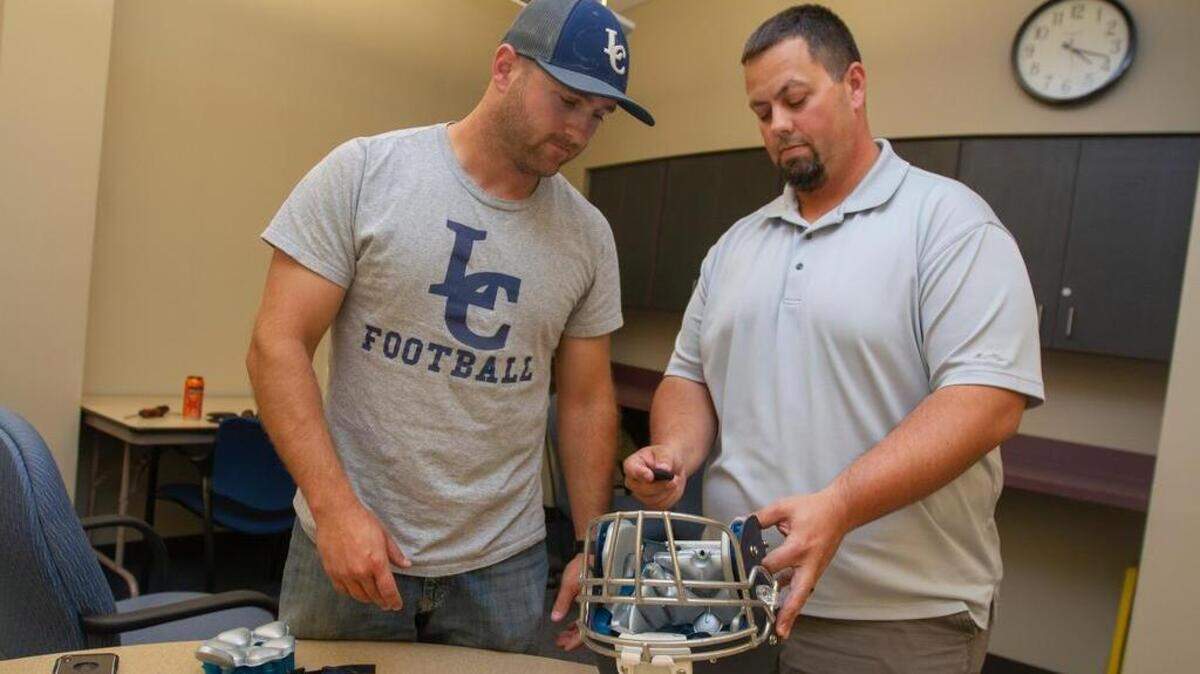 August 5, 2018 - Liberty Christian football coach Craig Lukins, left, and Jeff Boyus, president of the Kennewick Grid Kids Association, view the Cue sensor inside a football helmet. Liberty Christian is expected to be a title contender for the 2019  2B EWAC title.