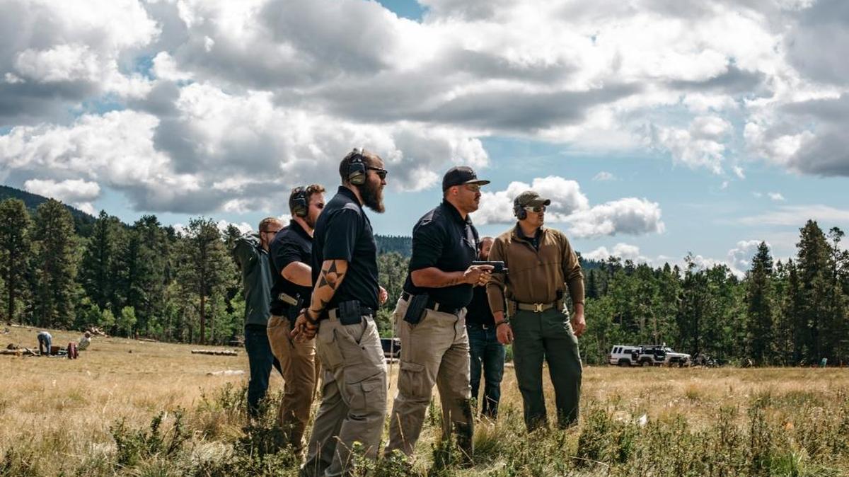 Curtis Simmons, foreground, instructs Samson Smith, with handgun, during an Iron Protection Group training session, outside Bailey, Colo.