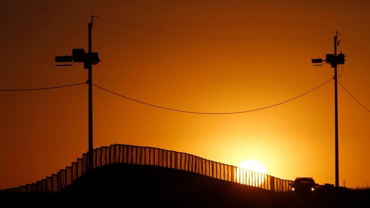 A sunset glows behind the U.S./Mexico border fence west of the Naco, Ariz., Port of Entry. Border Patrol agents in Arizona’s Pinal County Sheriff’s Office will become the nation’s first police agency at any level to use the Osa handgun, which shoots rubber bullets.