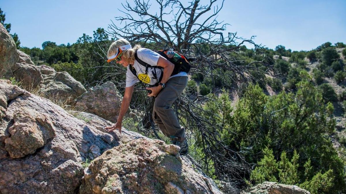 Cynthia Meachum hikes in search of treasure allegedly buried by a former fighter pilot and art dealer in the wilds near Cundiyo, N.M. Since losing her job last year, Meachum has worked full time to find the valuables whose location — real or not — was described by Forrest Fenn in his self-published memoir The Thrill of the Chase.