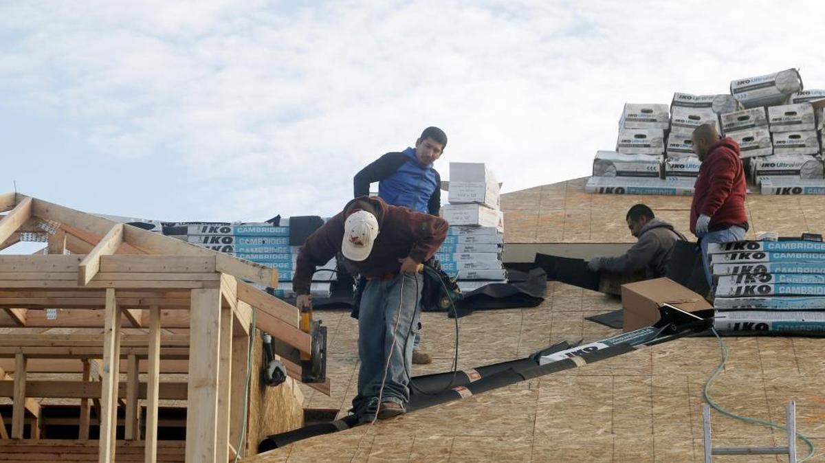 Construction workers work on the roof of a new home in Kennewick. In 2017, the Tri-Cities region saw an increase of 4 percent over 2016 with 1,446 new single-family home permits.