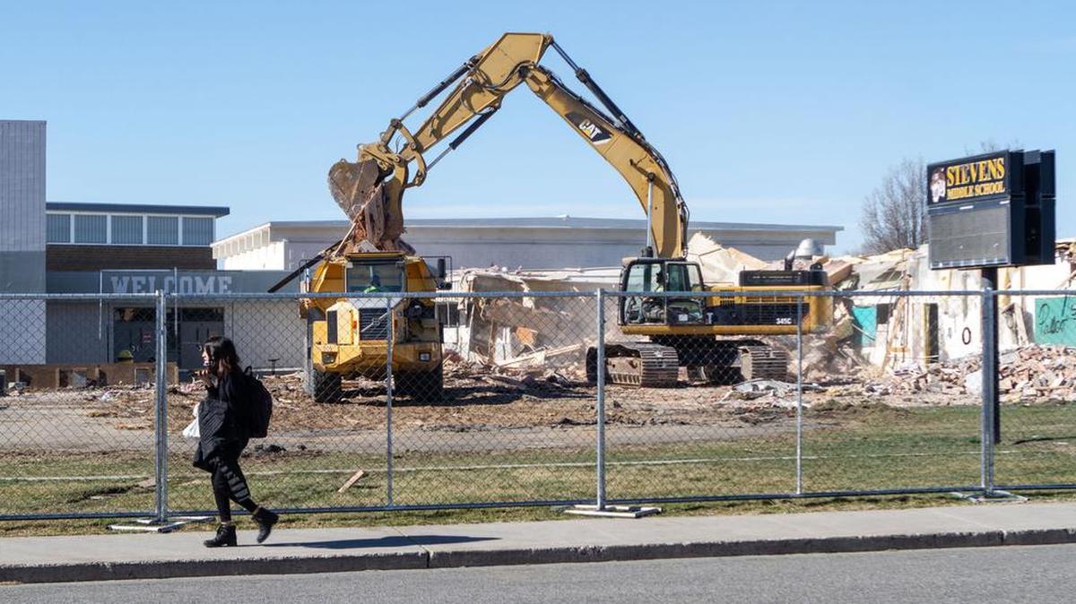 Students from Stevens Middle School in Pasco pass by the demolition of the old school building that is being torn down after a new $39.7 million school was built on the existing campus.