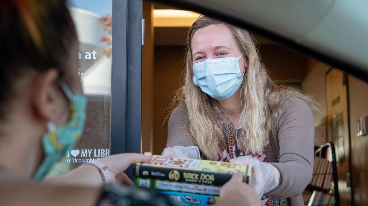 Customer Service Specialist Anna Lapp welcomes customers at Mid-Columbia Libraries’ West Pasco Branch drive-thru window in this promotional image.