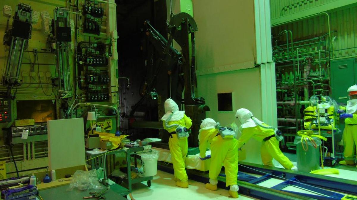 Workers at the 324 Building Disposition Project prepare to install a remotely operated excavator that crews will use to access highly radioactive soil beneath the building.