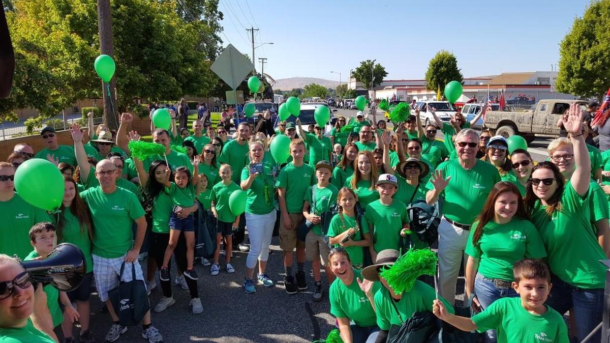 Trios employees prepare to walk the 2017 Benton Franklin Parade route and spread their brand of “green” cheer despite the challenges throughout the year.