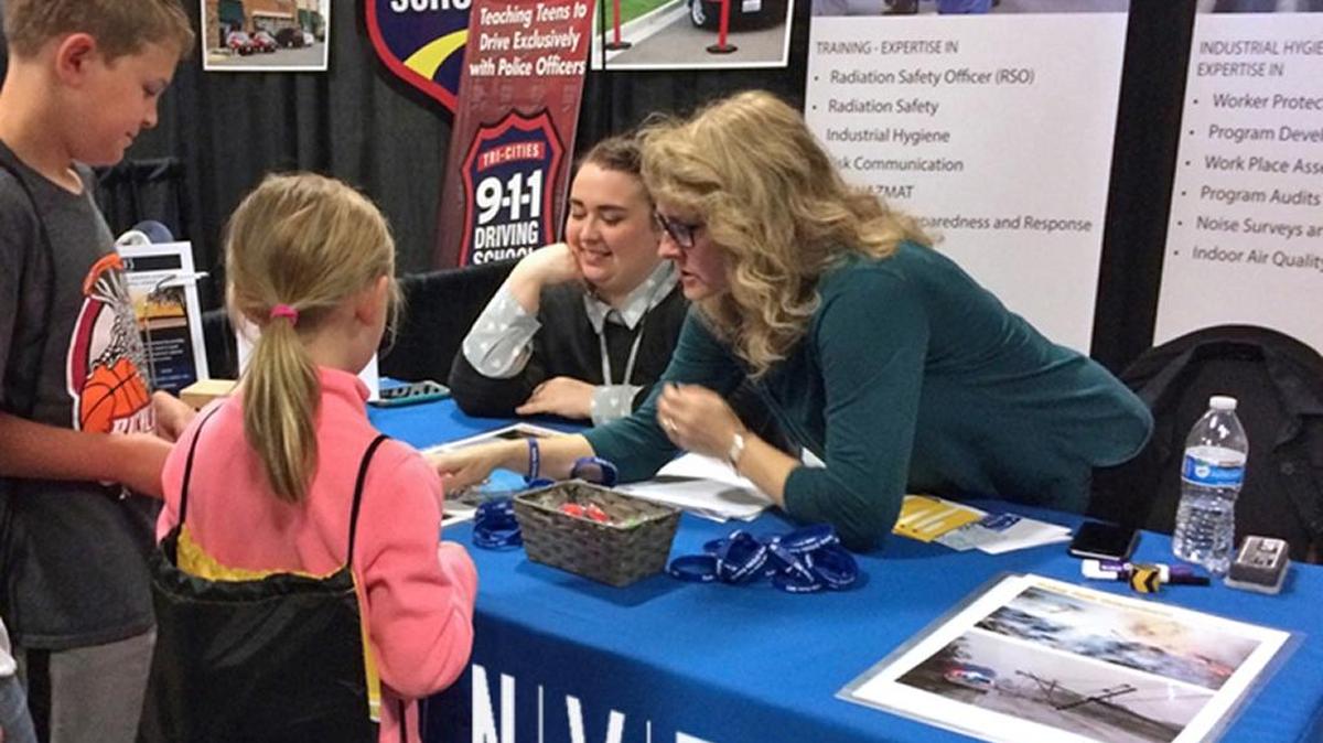 Catie Carlisle (L) and Susan Winslow (R) help local students spot safety violations in photos at the “Safety Connect” event.