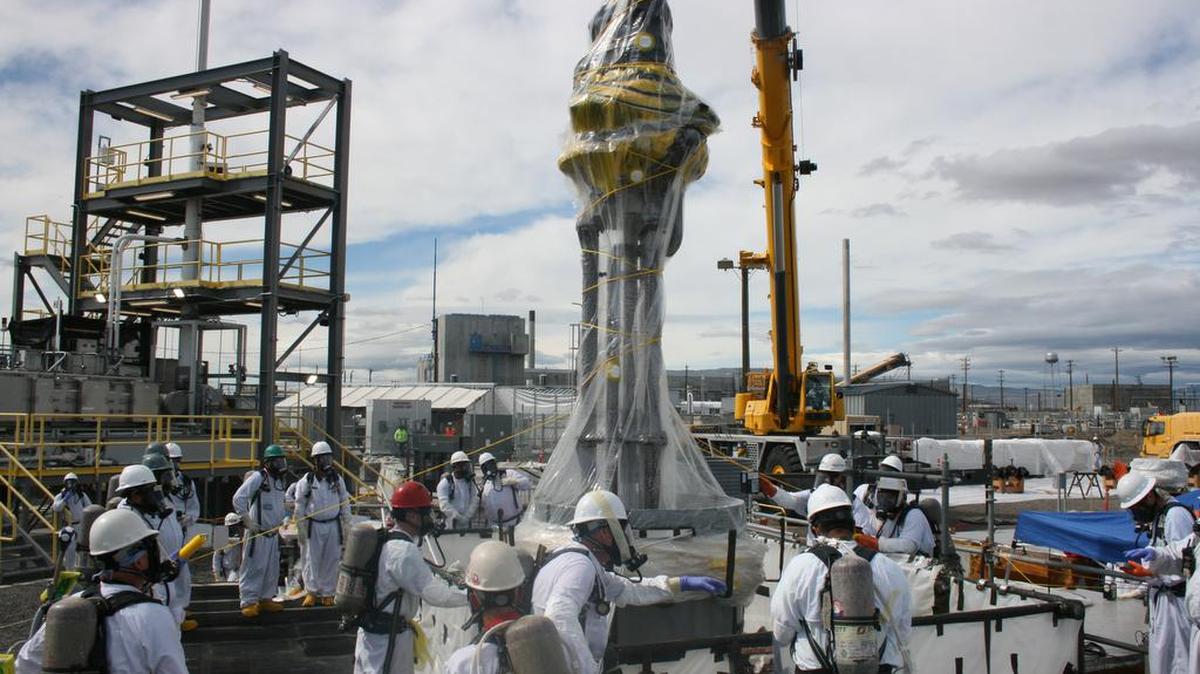 WRPS workers install a pump needed to retrieve radioactive and chemical waste from single-shell tank AX-102. Moving waste from older single-shell tanks to newer, more robust double-shell tanks is a key step toward eventual waste treatment.