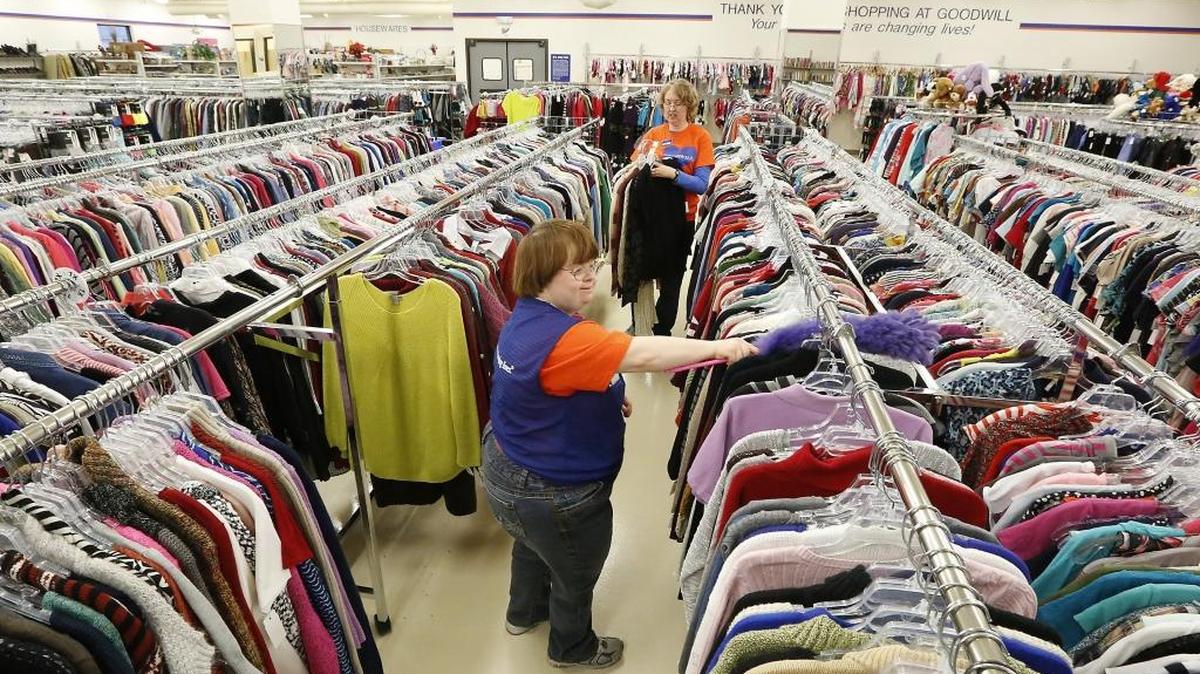 Client Jamie Arnold, left and lead cashier Debbie Simonen join a group of workers preparing the sales floor of the Goodwill Industries of the Columbia thrift store in east Kennewick.