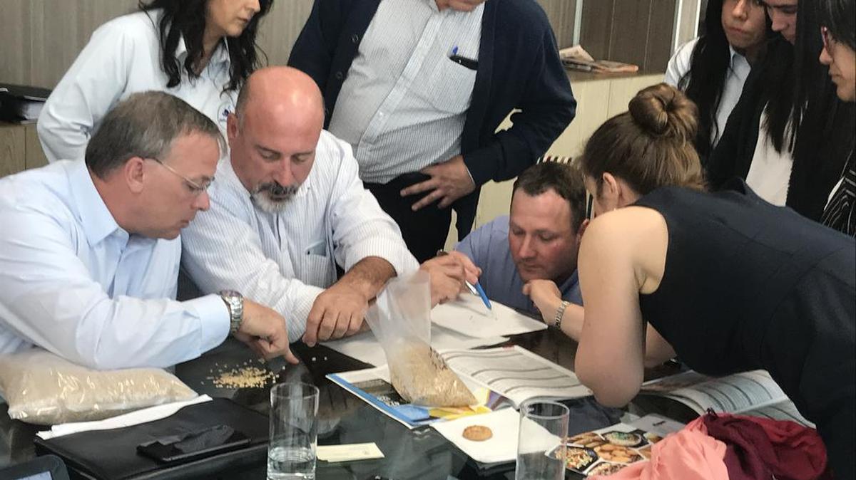 Mark Fowler, U.S. Wheat Associates vice president of overseas operations, and WGC commissioner Mike Miller look over samples with customers in Latin America.