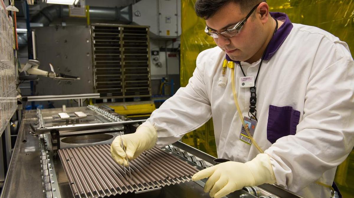 An employee inspects uranium fuel pellets that are inserted into fuel rods. Each pellet can provide as much fuel as 149 gallons of oil or 1 ton of coal.
