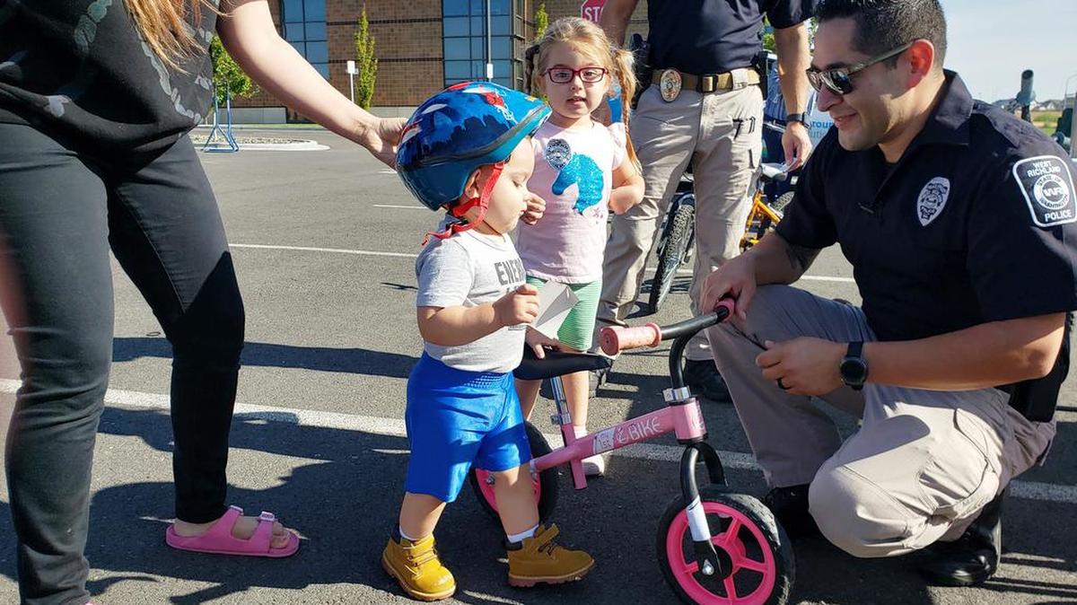 Officer Barrera helps young West Richland residents stay safe on their bikes.
