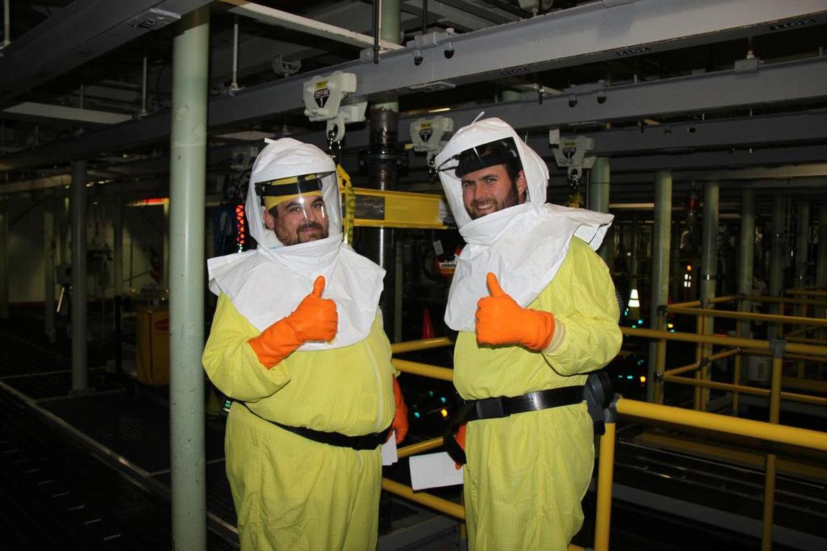 CH2M HILL Plateau Remediation Company employees Shay DeWitt (left) and Mike Garza (right) celebrate the first transfer of sludge from the 100 K West Basin to a container for storage on Hanford’s Central Plateau.