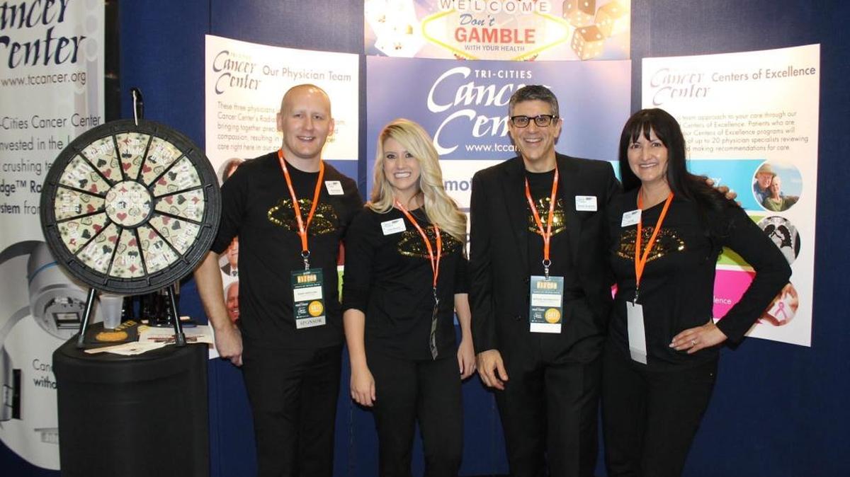 Randy Berglund, TCCC marketing specialist; Kylie Minnich, TCCC Foundation Donor relations coordinator; Michael Novakovich, TCCC director of business development and Lori Lott, TCCC Foundation special events coordinator are seen in the Tri-City Cancer Center booth at the Tri-City Regional Chamber of Commerce BIZCON 2015.