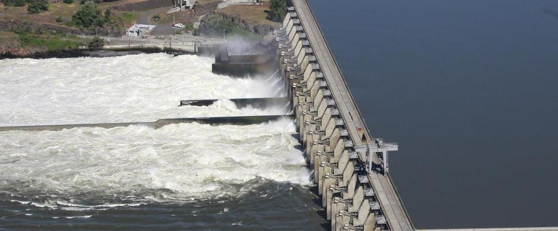 In this file photo, water flows through the Dalles Dam, along the Columbia River, in The Dalles, Ore. Negotiations with Canada to re-authorize the landmark Columbia River Treaty began early in 2018. The updating of the treaty affects the economy, environment, and flood control needs of millions of residents of the four states along more than 1,200 miles of the Columbia River and its tributaries.