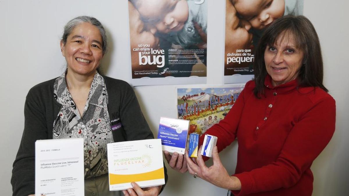 Dr. Amy Person, left, Benton-Franklin Health District health officer, and Heather Hill, program supervision, hold various vaccine options for the flu.