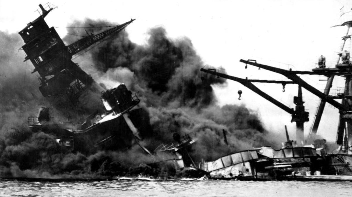 The battleship USS Arizona belches smoke as it topples over into the sea during a Japanese surprise attack on Pearl Harbor, Hawaii, in this Dec. 7, 1941 file photo. The ship sank with more than 80 percent of its 1,500 -man crew, including Rear Admiral Isaac C. Kidd. President Franklin D. Roosevelt announced that it was “a date which will live in infamy” and Congress declared war on Japan the morning after.