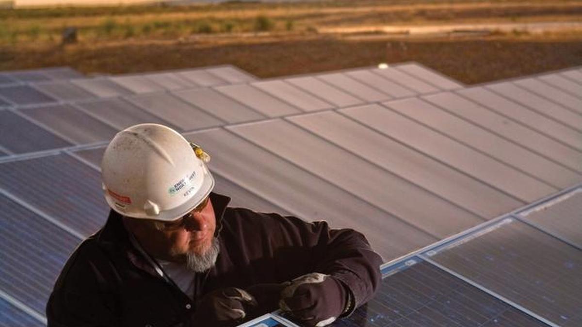 A worker checks solar panels at the White Bluffs Solar Station near Richland. A French firm is set to build a new solar station near the site.