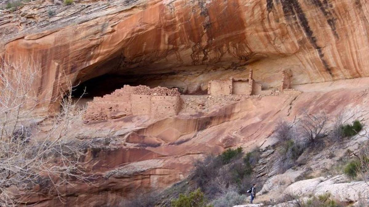 A hiker stands under a cliff dwelling in the Comb Ridge area of the new Bears Ears National Monument, in south Utah. President Barack Obama created the national monument before leaving office to protect Native American antiquities. Utah Republicans are lobbying the Trump administration to change the designation.