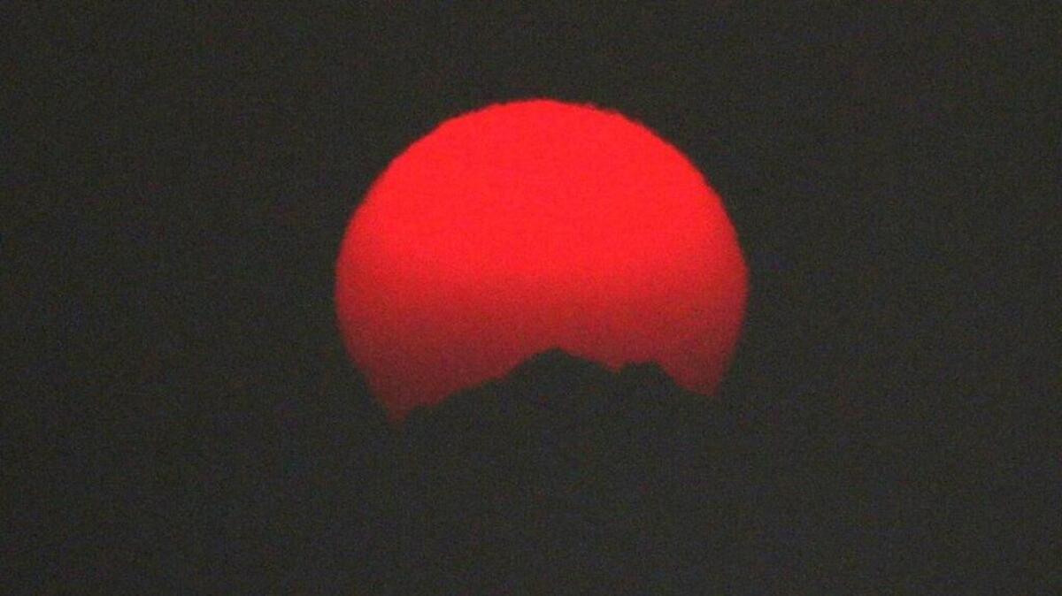 The sun setting over the Olympic Mountains was a brilliant red last summer because smoke from wildfires in British Columbia swept into the Puget Sound region. Scientists say climate change is a contributing factor to an increase in forest fires in recent years.