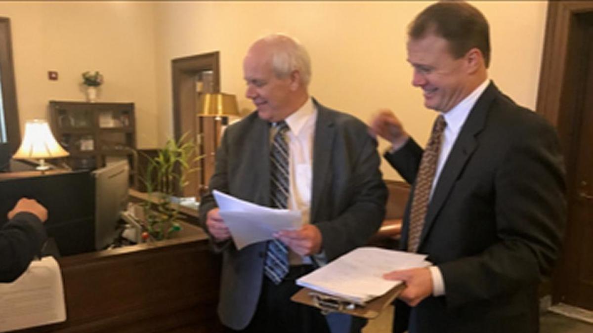 State Treasurer Duane Davidson and Tim Eyman share a laugh as Eyman hands him a formal complaint over the Legislature’s decision to divert new revenue away from the Rainy Day Fund. Eyman is a political watchdog and said he knows Davidson opposed the legislative proposal, but as state treasurer he must be named in the lawsuit.