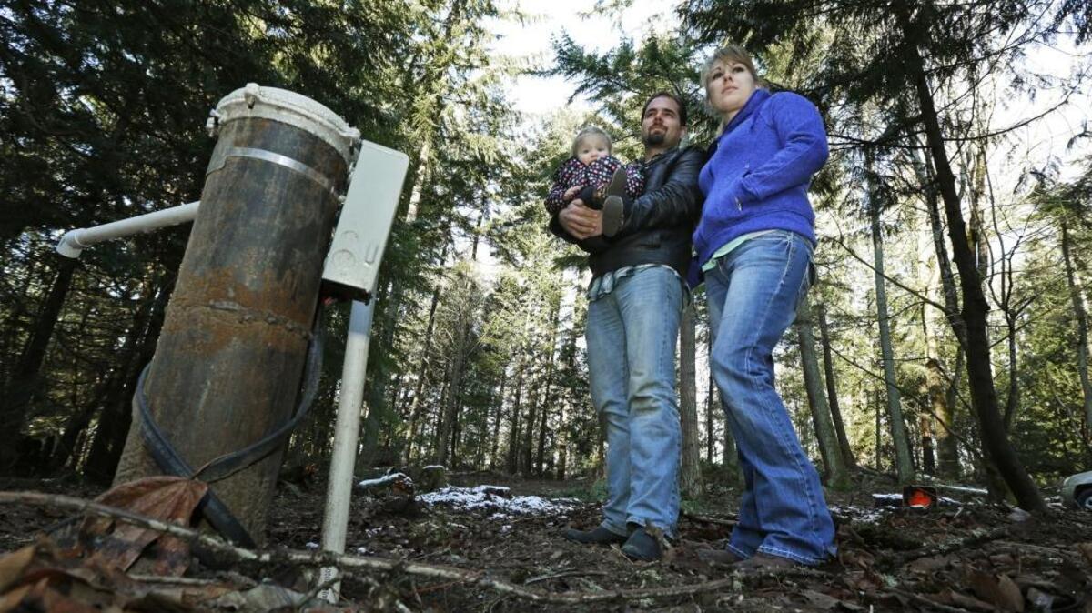 In this 2016 photo, Bud Breakey and his wife Deborah pose by the water well they paid to drill on their property near Bellingham, where they hoped to build a house. Their plans have been complicated by a state Supreme Court decision that put the onus on counties to determine if water is legally available in certain areas before they issue building permits. Legislation that would help solve the issue has been introduced this legislative session.