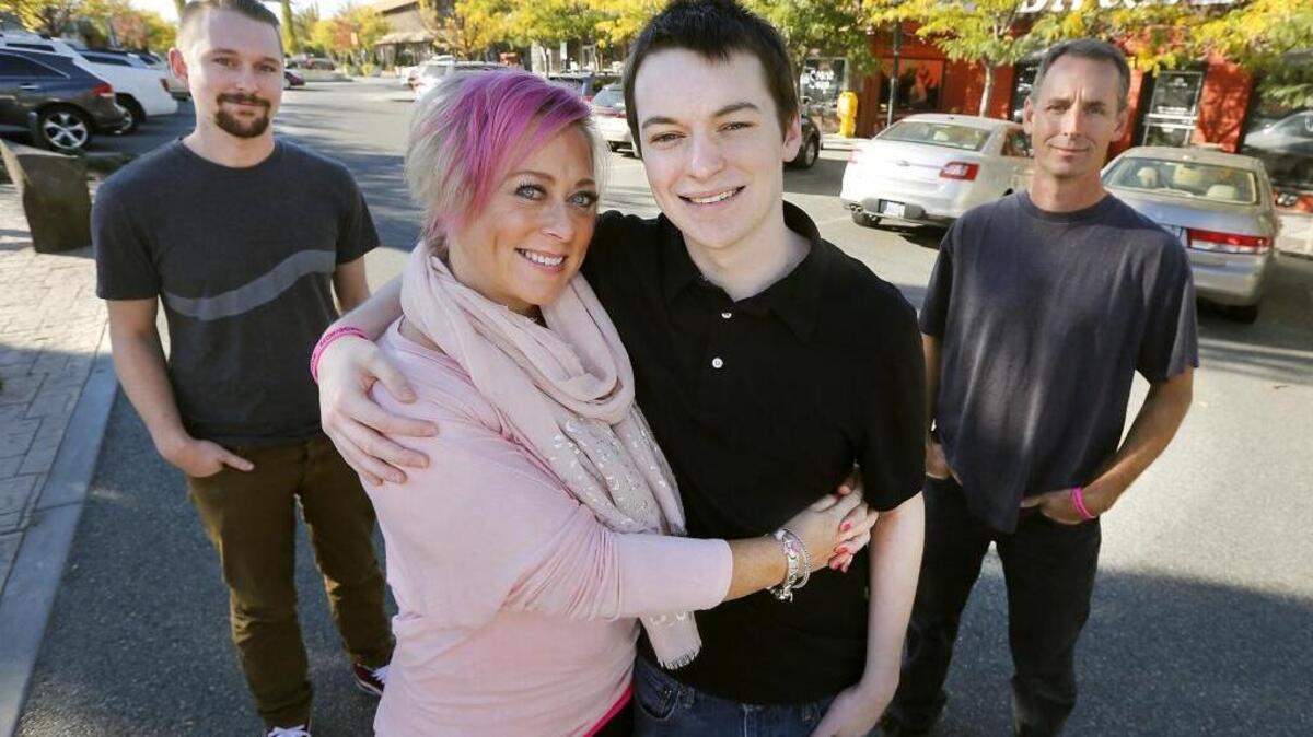 Warrior Sisterhood co-founder Pam Frick hugs her youngest son, Chance, who was born after her she received chemotherapy treatments for breast cancer while she was pregnant with him nearly 20 years ago. Her husband, Glenn, right, and oldest son, Justin, 23, stand with them recently at the The Parkway in Richland. The cancer support group she helped organize the third annual fundraiser called Pink the Parkway last weekend.