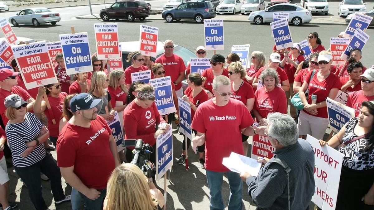 
Greg Olson, president of the Pasco Association of Educators, is surrounded by picketing teacher union members Sept. 1 as reporters get his response to the Pasco School District taking legal action against the striking union.
