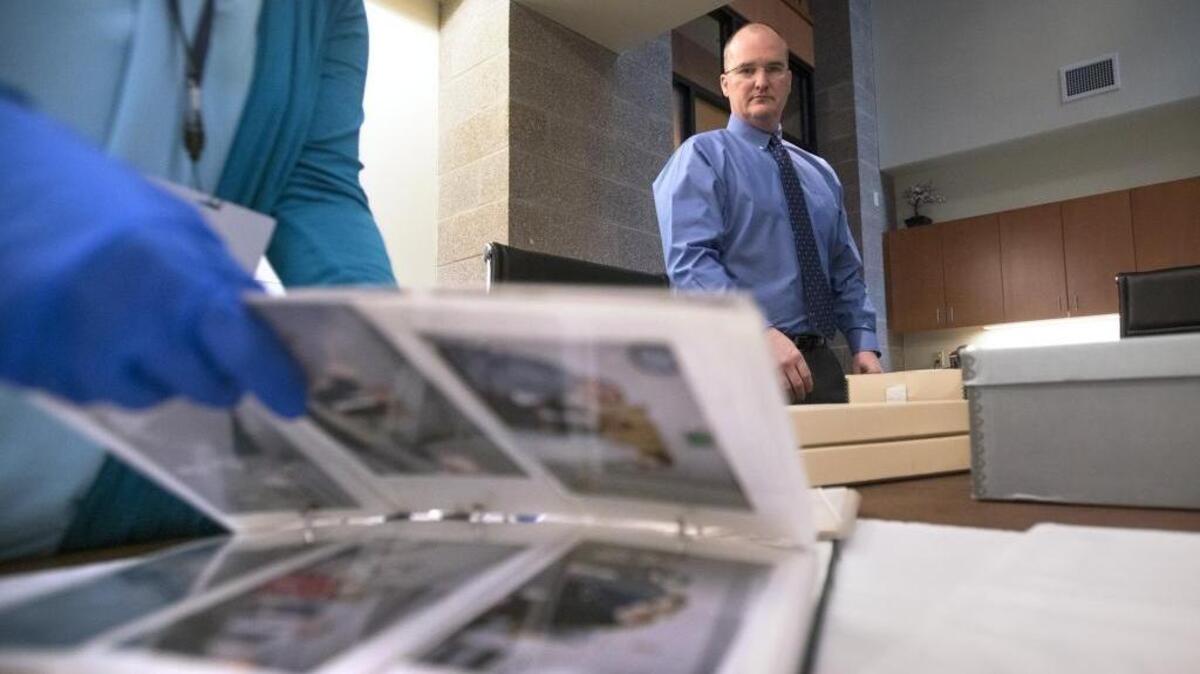 Lacey city manager Scott Pence looks over some of the estimated 80,000 pictures that his staff are pulling to fulfill a public records request for “every photo” in the city archive, shown at Lacey City Hall on Wednesday, March 8, 2017.