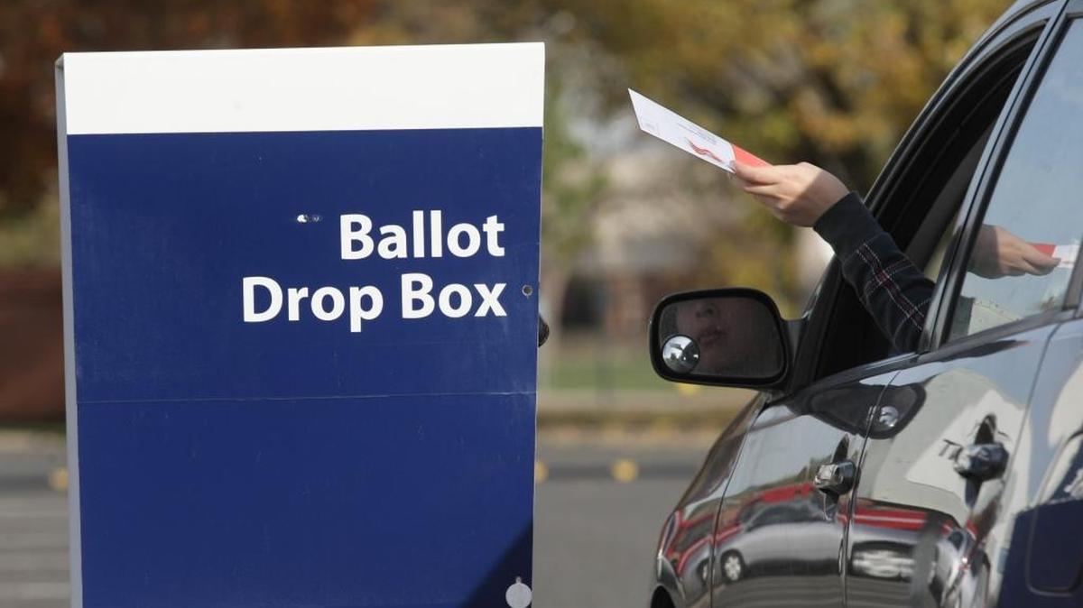 A Benton County voter drops off a ballot on Election Day at Kennewick City Hall.