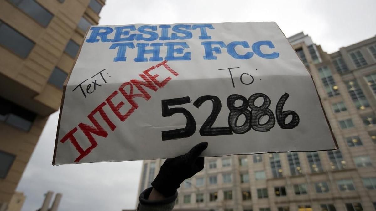 A protester holds a sign at the Federal Communications Commission (FCC), in Washington, Thursday, Dec. 14, 2017. The FCC voted to eliminate net-neutrality protections for the internet.
