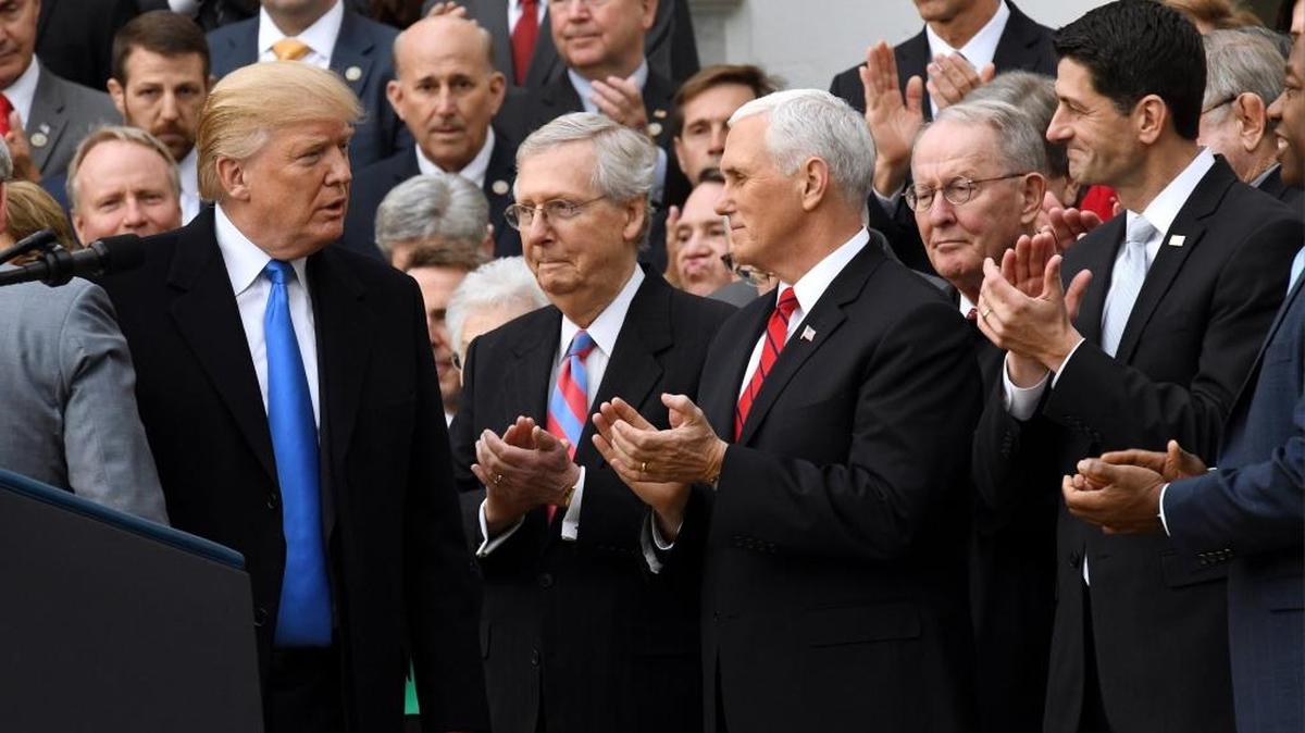 From left, President Donald Trump, Senate Majority Leader Mitch McConnell, Vice President Mike Pence and House Speaker Paul Ryan celebrate the tax bill’s passage with members of the House and Senate on Dec. 20, 2017.