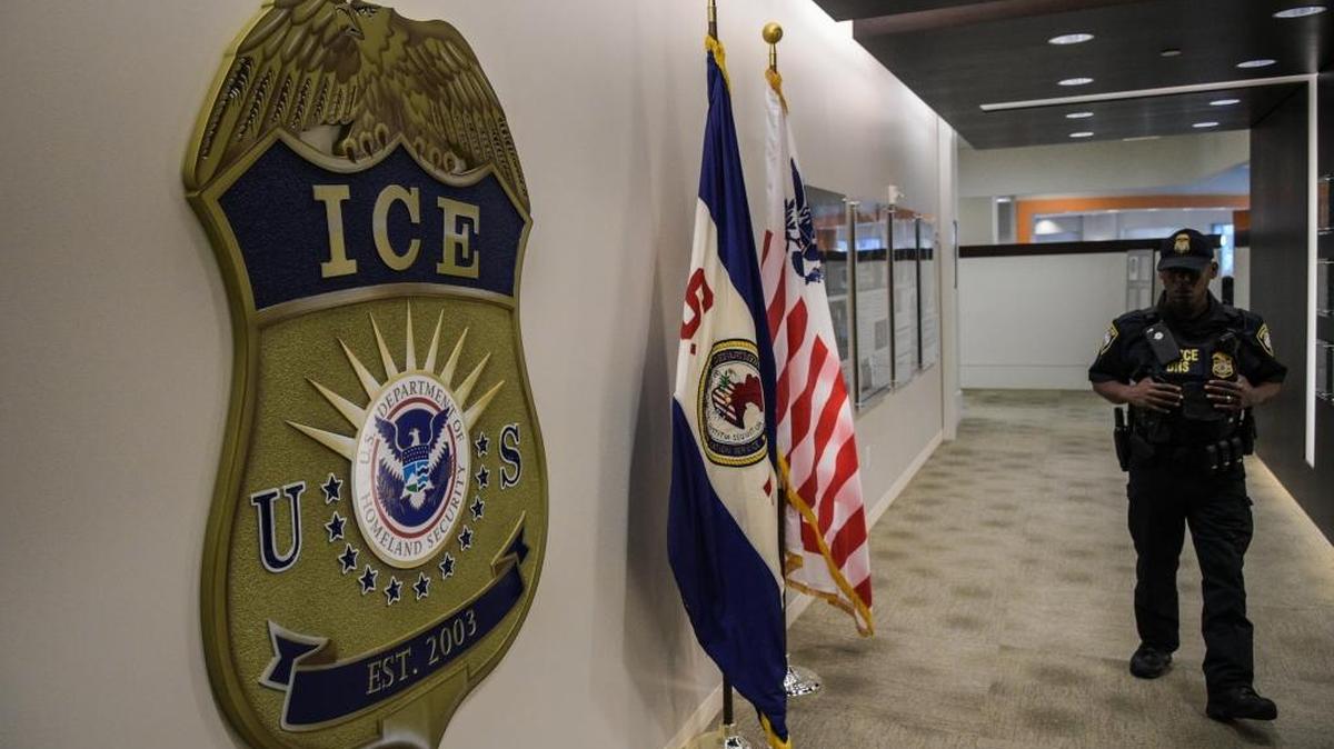 A law enforcement officer walks past the ICE logo at the U.S. Immigration and Customs Enforcement headquarters in Washington, D.C.