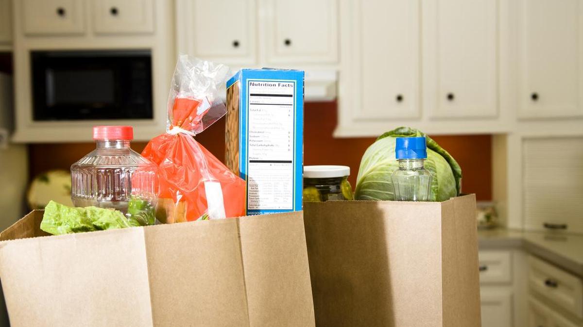 Full grocery bags sitting on the kitchen counter.