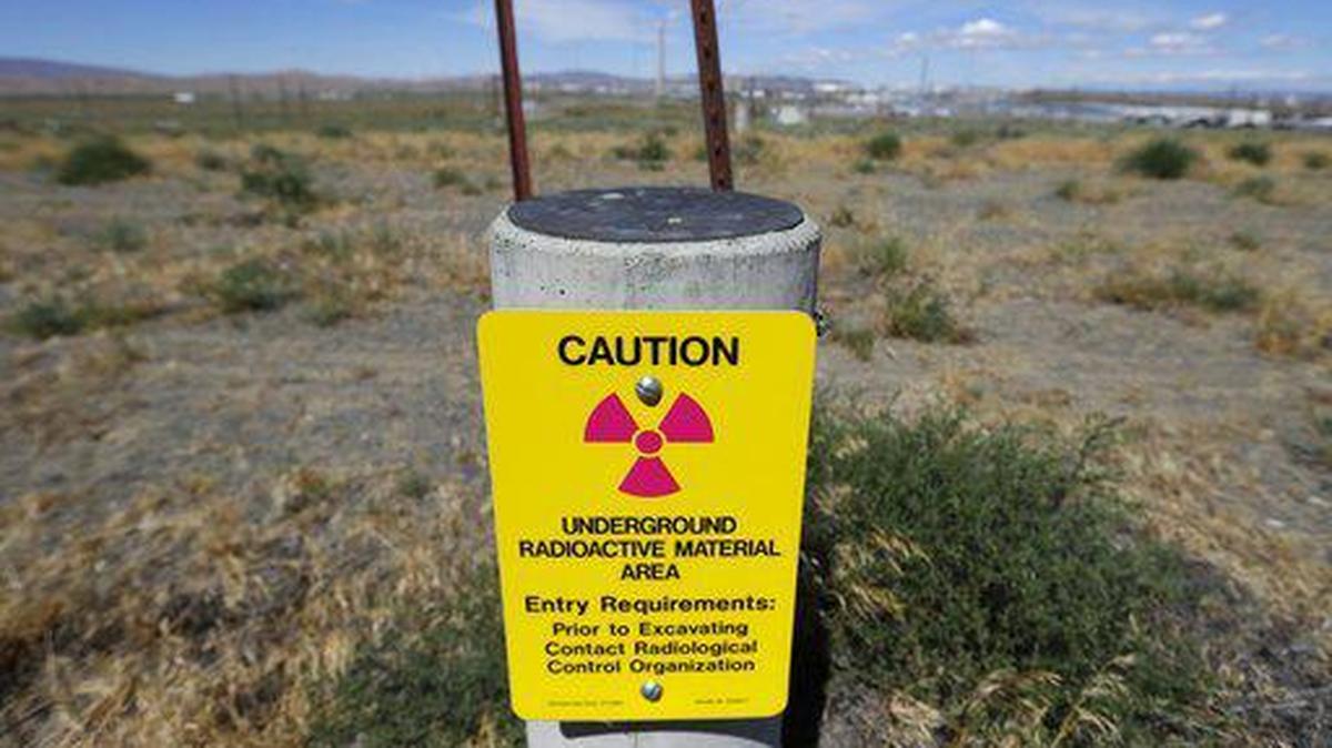 In this photo taken July 11, 2016, a sign warns of radioactive material stored underground on the Hanford Nuclear Reservation near Richland, Wash.