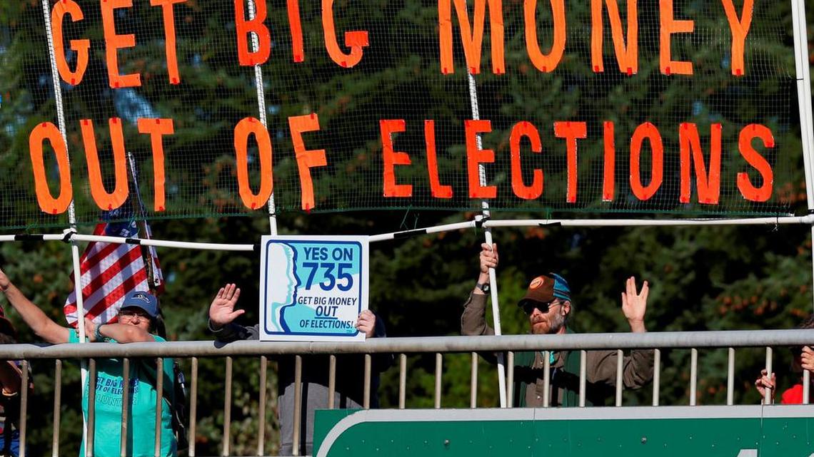  In this Sept. 22, 2016, file photo, citizens hold a banner above the I-5 freeway during the evening commute in Lacey, Wash., opposing the U.S. Supreme Court's ruling in the Citizens United case.