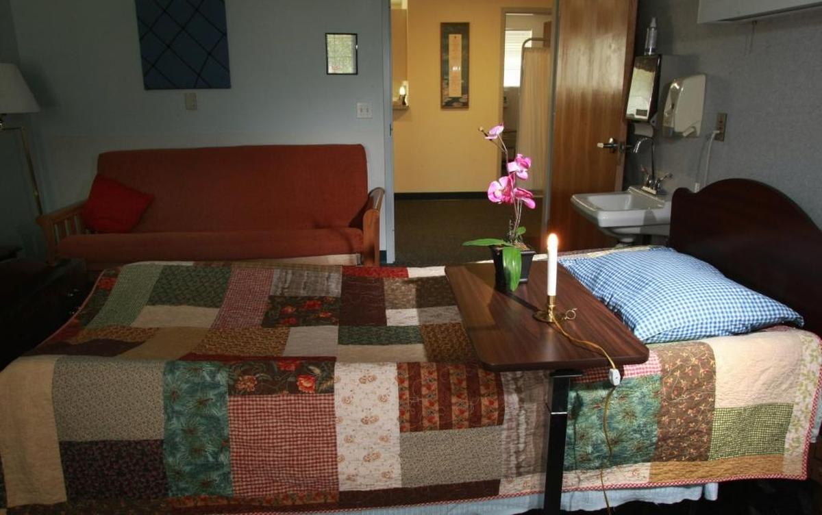 A single candle-style bulb and flowers sit in a room at the Hospice House in Kennewick. Staff place the tribute in each room after a death, and the room is not used for 24 hours. Volunteer Colette Jorgenson says, “We always say we celebrate life at Hospice, not death.” Herald/Bob Brawdy #1