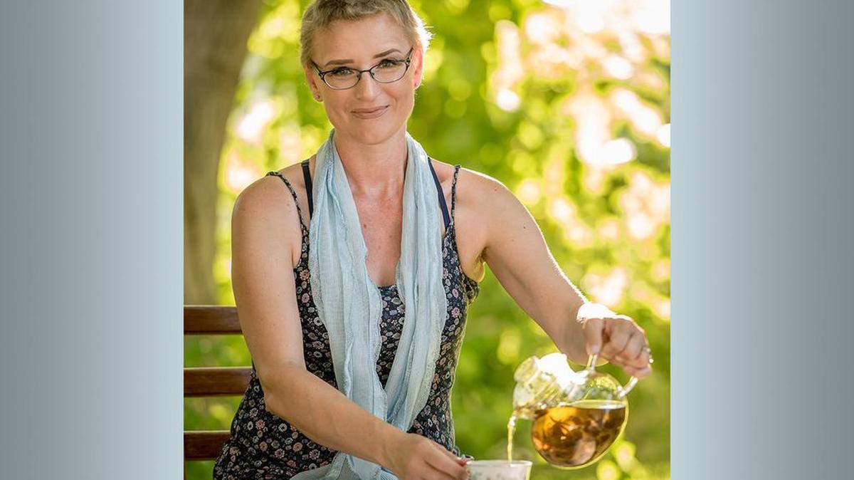 Libby Boothe of Kennewick pours tea during a photo shoot for a Warrior Sisterhood calendar in this 2017 photo. The tea party photo is a nod to the annual Witches’ Tea Party she held every October in conjunction with her birthday, a tradition she kept up even while fighting Stage 4 breast cancer. She died July 23 at age 44. 