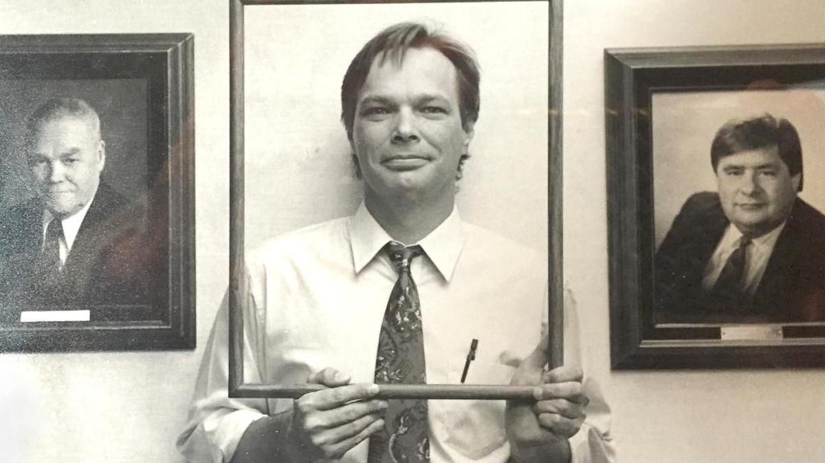Former Tri-City Herald editorial page editor Chris Sivula frames himself between photos of publishers Glenn C. Lee, the Herald’s first publisher, and Kelso Gillenwater.