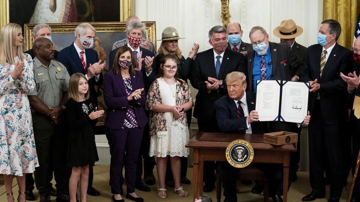 President Donald Trump displays a signed version of H.R. 1957 - The Great American Outdoors Act, in the East Room of the White House in Washington, on Tuesday, Aug. 4, 2020.