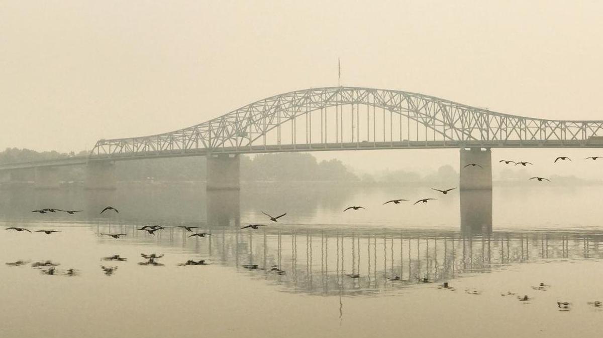 Birds fly in the smokey Tri-City sky near the blue bridge on Thursday. The smoke is due to the Eagle Creek Fires east of Portland.